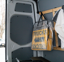 Load image into Gallery viewer, Clear storage bag of yellow TRUCKS location signs hanging inside a van
