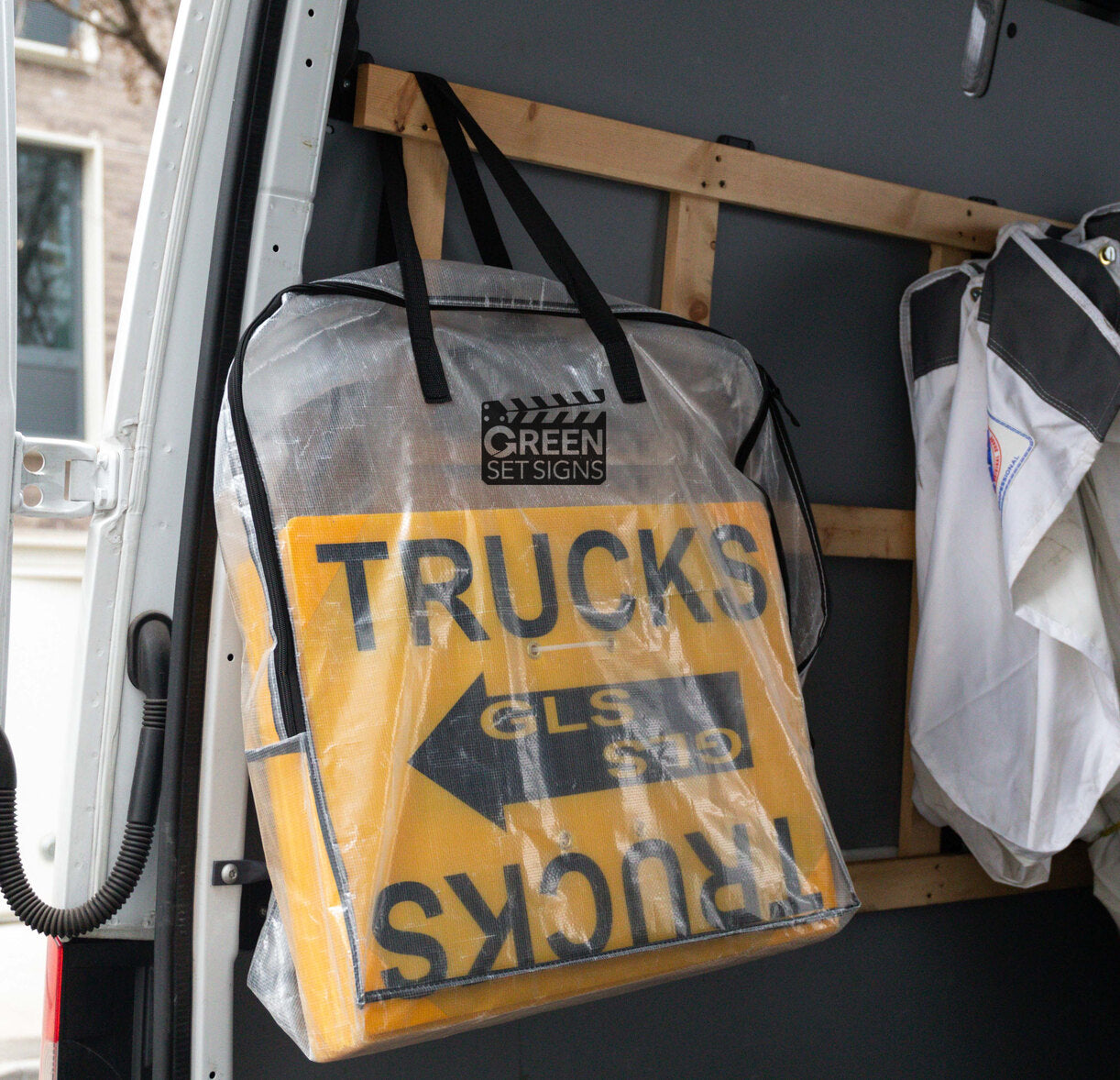Clear storage bag of yellow TRUCKS location signs hanging inside a van